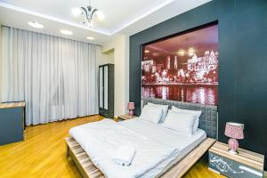 ein Schlafzimmer mit einem großen Gemälde an der Wand in der Unterkunft Apartment On VIP Nizami Street in Baku