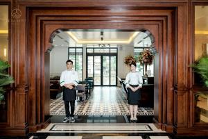 a couple of people standing in a lobby at De La Mont Hotel Ha Giang in Ha Giang