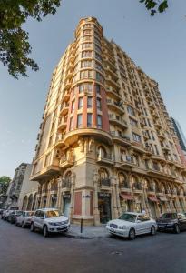 ein großes Gebäude, vor dem Autos parken in der Unterkunft Apartment On VIP Nizami Street in Baku