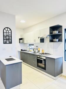 Una cocina grande con gabinetes blancos y electrodomésticos grises. en Elusive Haven, en Nelspruit