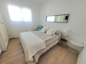 una camera da letto con un letto con uno specchio sul muro di Candela con amor a Punta Umbría