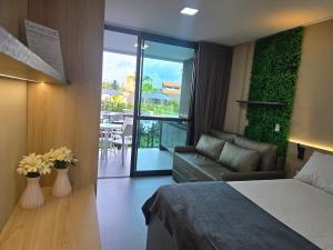 ein Hotelzimmer mit einem Bett und einem Sofa sowie einem Balkon in der Unterkunft Beach Class Summer Residence em Porto de Galinhas in Porto De Galinhas + 31 Fotos
