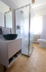 Un baño con lavabo y ducha de cristal. en Komorebi, en Locatello