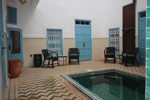 eine Terrasse mit Stühlen und einen Pool in einem Haus in der Unterkunft Palais el Abbassia in Marrakesch