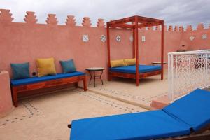 ein Raum mit zwei blauen Bänken und einer Wand in der Unterkunft Palais el Abbassia in Marrakesch