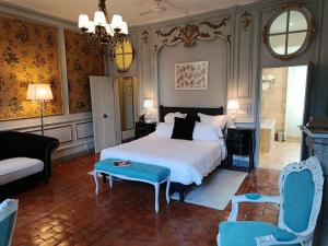 a bedroom with a bed and a couch and a chair at Les Glycines Vézelay in Vézelay