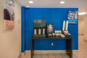 un mur bleu avec une table et des bouteilles de vin dans l'établissement Motel 6-Milford, CT, à Milford