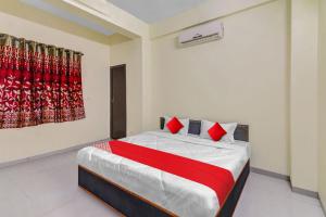 une chambre avec un lit avec des oreillers rouges dans l'établissement Hotel O King's Inn, à Dhantoli 27 autres photos