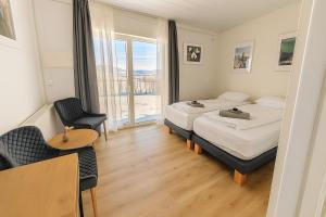 Una habitación de hotel con dos camas y una ventana. en The Hvítá Inn by Ourhotels, en Bær