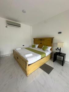 Schlafzimmer mit einem Holzbett und einem Tisch in der Unterkunft OrientalResort Kekirawa in Kekirawa + 12 Fotos