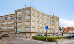 a large building with cars parked in front of it at Appartemment familial à Westende in Westende-Bad