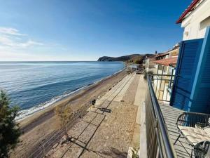 a view of the beach from the balcony of a house at Aegean View Apartment in Skala Eresou