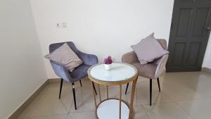two chairs and a table in a room at The Petrance Apartment in Cape Coast +84 photos