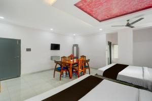 a bedroom with a bed and a table with chairs at Collection O Karmanghat Bus Terminal Hyderabad Formerly Hotel Chirag Stays in Hyderabad