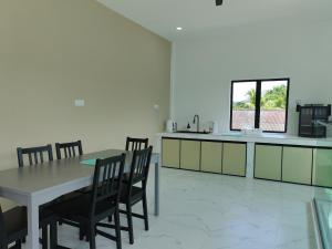 a kitchen with a table and chairs and a window at 8ight Guesthouse 8号民宿 in Kluang