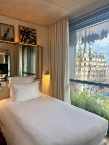 a bedroom with a bed and a large window at Villa M in Paris