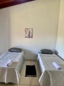 deux lits côte à côte dans une pièce dans l'établissement Hotel Colonial Lençois, à Lençóis Paulista