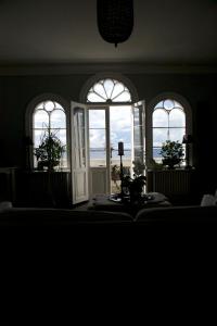 a room with three windows with a view of the ocean at Von Otterska Villan i Gränna in Gränna