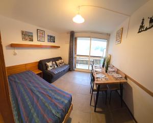 a living room with a table and a couch at Appt pied pistes et centre station Superdévoluy chez Locasoleil in Le Dévoluy