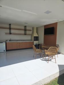 Zimmer mit Stühlen, einem Tisch und einem Kamin in der Unterkunft Apto 250mt Praia Coroa Vermelha 2 Quartos com Ar Condicionado in Porto Seguro