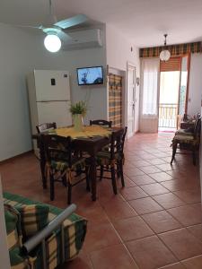 a dining room with a wooden table and chairs at APPARTAMENTO 21 in San Vito lo Capo +23 photos