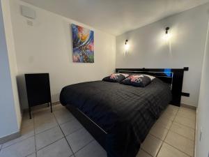 a bedroom with a bed and a painting on the wall at Cinéma Room - La Valette - Toulon - Hyères in La Valette-du-Var