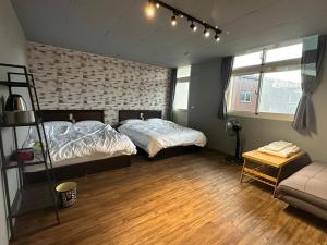 a bedroom with two beds and a couch in it at 輕鬆玩民宿 in Luodong