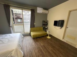 a hotel room with a bed and a chair and a window at Easy play B&B in Luodong