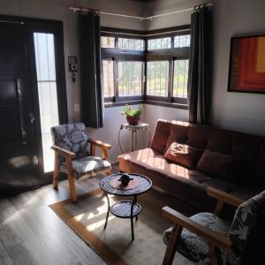 ein Wohnzimmer mit Sofa und Tisch in der Unterkunft A Casa Amarela - Morada dos Maçaricos - Tranquilidade próxima ao mar in Balneário Gaivotas