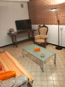 ein Wohnzimmer mit einem Tisch und einem Schreibtisch mit einem Laptop in der Unterkunft La roccia in Mezzanego