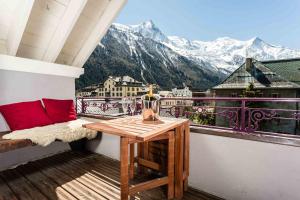 d'un balcon avec une table et une vue sur les montagnes. dans l'établissement Villa Vallet Apartment - Chamonix All Year, à Chamonix-Mont-Blanc