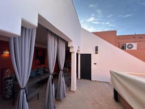 Zimmer mit weißen Wänden und grauen Vorhängen in der Unterkunft Your Soul's Retreat-Entire Riad in Marrakesch
