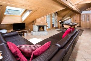 - un salon avec un canapé en cuir et une cheminée dans l'établissement Villa Vallet Apartment - Chamonix All Year, à Chamonix-Mont-Blanc
