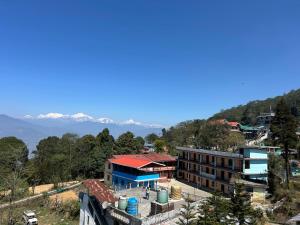 a building on a hill with mountains in the background at The Jasmit Mount View Homestay in Kalimpong
