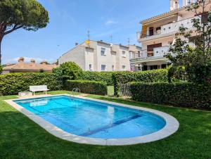 a swimming pool in a yard next to a building at Apartamento Playa in S'Agaro