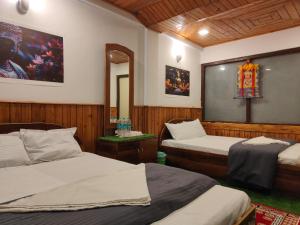 a bedroom with two beds and a mirror at The Jasmit Mount View Homestay in Kalimpong