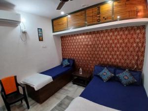 ein kleines Zimmer mit 2 Betten und einem Stuhl in der Unterkunft Kashvi Homestay in Varanasi