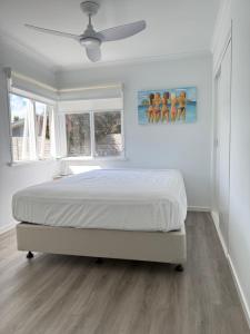 a bedroom with a bed and a ceiling fan at Beach House Getaway 1 in Smiths Beach