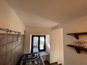 une cuisine avec une cuisinière et une fenêtre dans l'établissement Il Ghiro, à Rollieres