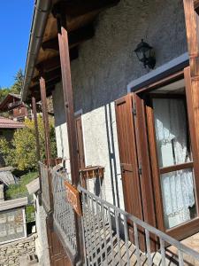 une terrasse couverte d'une maison avec une porte en bois dans l'établissement Il Ghiro, à Rollieres