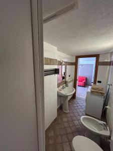 une salle de bain avec deux toilettes et un lavabo dans l'établissement Il Ghiro, à Rollieres