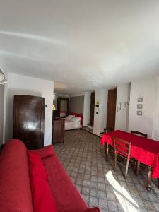 un salon avec un canapé rouge et une table dans l'établissement Il Ghiro, à Rollieres