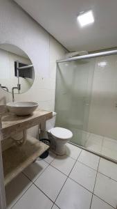 a bathroom with a toilet and a glass shower at Apartamento in Rio Verde +4 photos