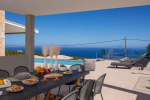 Ilania Luxury Villas في تسوكالادهيز: طاولة الطعام فوق المنزل