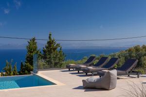 Ilania Luxury Villas في تسوكالادهيز: جلسة مجموعة كراسي الصالة بجانب المسبح