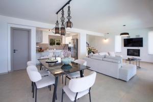 Ilania Luxury Villas في تسوكالادهيز: غرفة طعام وغرفة معيشة مع طاولة وكراسي