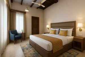 ein Schlafzimmer mit einem großen Bett und einem blauen Stuhl in der Unterkunft The Ceylon Olive Resort in Katunayaka