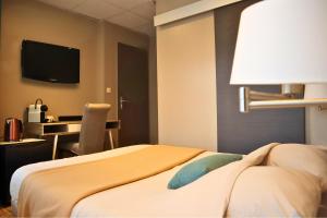 une chambre d'hôtel avec deux lits et une télévision à écran plat dans l'établissement La Pause Voyage - chambre privative, gare à proximité, à Bourbourg