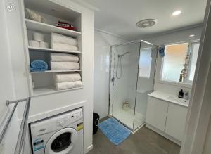 a bathroom with a washing machine and a shower at Beach House Getaway 1 in Smiths Beach