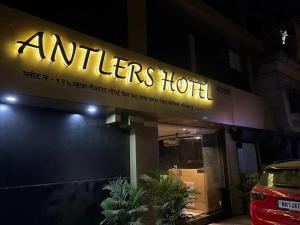 una señal encendida en el lateral de un edificio en ANTLERS HOTEL Near Borivali Railway Station, en Jāmb